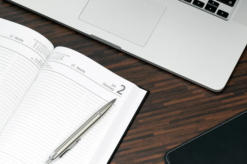 Fotografie eines Terminplaners und eines Laptops